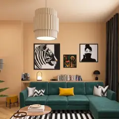 Gemütliches Wohnzimmer mit smaragdgrünem Sofa, auffälligen Kunstwerken und warmen Farbkombinationen an der Wand.
