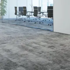 Moderner Teppichboden in Grau auf grauen Fliesen, der einen stilvollen Übergang zu einem Konferenzraum mit Glaswänden und Bürostühlen schafft.