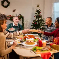 Familie feiert Weihnachten minimalistisch am festlich gedeckten Tisch. Ein Weihnachtsbaum und Kerzen sorgen für stimmungsvolles Licht.