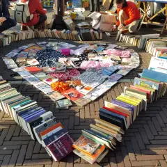 Herzförmige Anordnung von Büchern und CDs auf einem Flohmarkt. Tolle Flohmarkt Stand Ideen für Bücherliebhaber.
