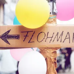 Bunte Ballons und ein handgemalter Pfeil auf Pappe weisen den Weg zum Flohmarkt. Perfekt für deine Flohmarkt-Checkliste!