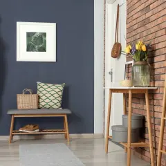 Ein Flur mit dunklem Wandfarben-Trend, Garderobe, Bank, Spiegel und Tulpen.