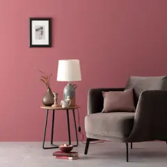 Gemütliche Ecke mit einem Sessel und Beistelltisch. Die Wand in einem warmen, englischen Rosenrot kombiniert mit dunklen Möbeln und Deko.