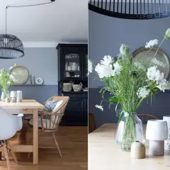 Schöne Esszimmer Wand Ideen: Ein Holztisch mit weißen Stühlen, ein schwarzer Schrank und ein Blumenstrauß.