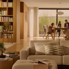 Familie am Esstisch, ein Sessel und ein Sofa in warmen, beigen Tönen. Die beige Wirkung schafft eine gemütliche Atmosphäre.