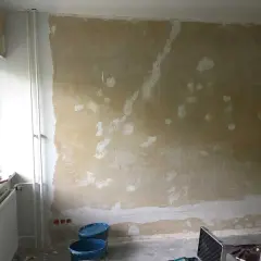 Vorbereitung für das selbst tapezieren: Wand ist vorbereitet, Werkzeug und Eimer stehen bereit.