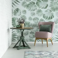 Ein Sessel und ein Tisch stehen vor einer Wand mit versetztem Ansatz Tapete im tropischen Stil.