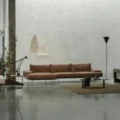 Modernes Wohnzimmer mit Ledersofa, Couchtisch und einem dunklen Boden, der die minimalistische Einrichtung unterstreicht.