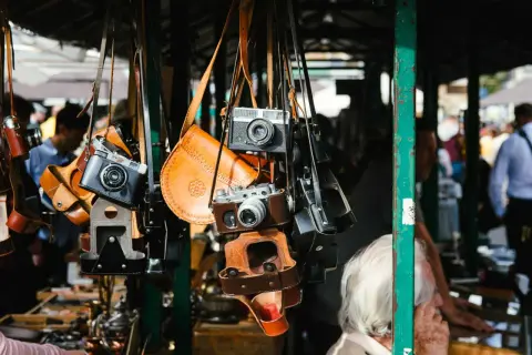 Alte Kameras und Lederetuis hängen an einem Stand. Vintage-Fotografie-Ausrüstung auf dem Flohmarkt, was verkauft sich gut?