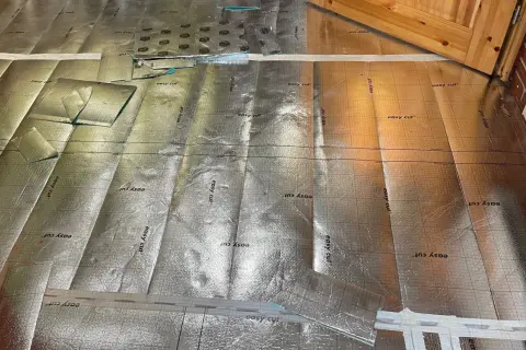 Bodenisolierung mit reflektierender Folie, bereit für die Verlegung im Badezimmer. Kork wird später darauf angebracht.