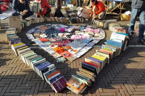 Herzförmige Anordnung von Büchern und CDs auf einem Flohmarkt. Tolle Flohmarkt Stand Ideen für Bücherliebhaber.