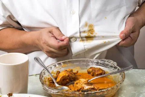 Fettflecken auf weißem Hemd nach dem Essen. Tipps, wie man Fettflecken auf Raufasertapete entfernen kann, sind hier nicht relevant.