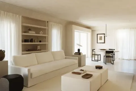 Minimalist Wohnzimmer mit weißem Sofa, Beistelltischen und Essbereich. Ein Beispiel für einen modernen Lebensstil, der Ruhe und Ordnung ausstrahlt.
