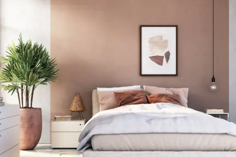 Sanfte Rosatöne und erdige Akzente für deine wandfarben schlafzimmer inspiration. Ein gemütliches Bett mit vielen Kissen und eine grüne Pflanze schaffen Wohlfühlatmosphäre.