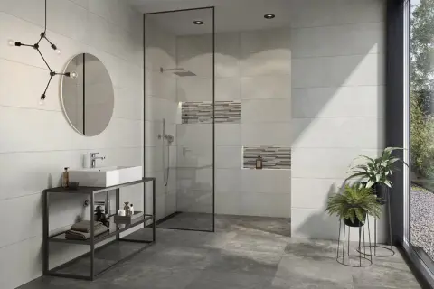 Modernes Bad mit Dusche, Waschbecken und Pflanzen. Die Wandfliesen mit Betonoptik verleihen dem Raum einen industriellen Touch.