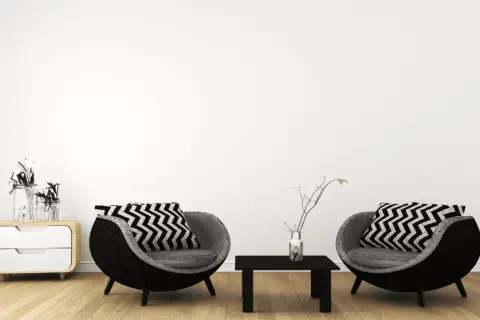 Zwei runde Sessel mit Zickzackkissen, ein kleiner Tisch und ein Nachttisch mit Vasen – ein Einblick in minimalistisch leben erfahrungen.