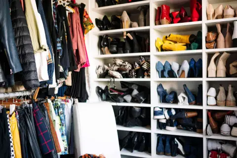 Kleiderschrank voller Schuhe und Kleidung. Zeit, Kleidung zu reduzieren und Ordnung zu schaffen.