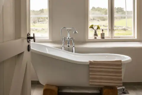 Ein freistehendes Bad mit rustikalem Charme. Hier wird "bad aus alt mach neu" perfekt umgesetzt, mit einer modernen Armatur und einem Handtuch, das Gemütlichkeit ausstrahlt.