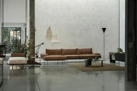 Modernes Wohnzimmer mit Ledersofa, Couchtisch und einem dunklen Boden, der die minimalistische Einrichtung unterstreicht.