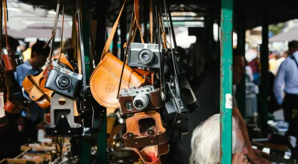 Alte Kameras und Lederetuis hängen an einem Stand. Vintage-Fotografie-Ausrüstung auf dem Flohmarkt, was verkauft sich gut?
