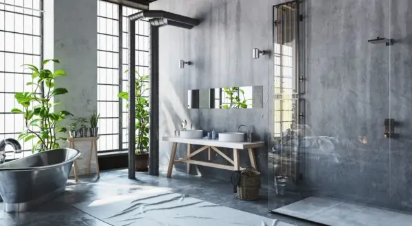 Badezimmer im bad industrielook mit Betonwänden, freiliegenden Rohren, einer Metallbadewanne und Pflanzen.