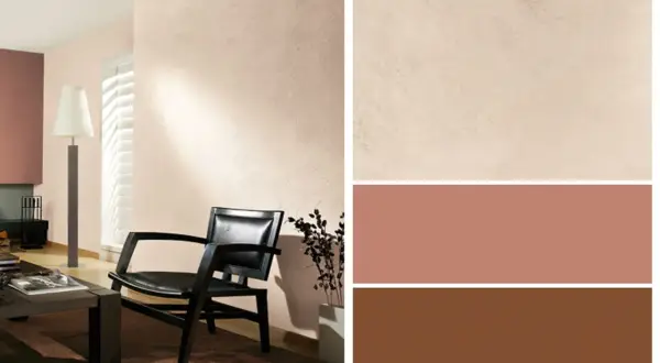 Gemütliche Wandfarbe kombinieren: Ein schwarzer Ledersessel vor einer hellbeigen Wand, daneben Farbfelder in Beige, Rosé und Braun.