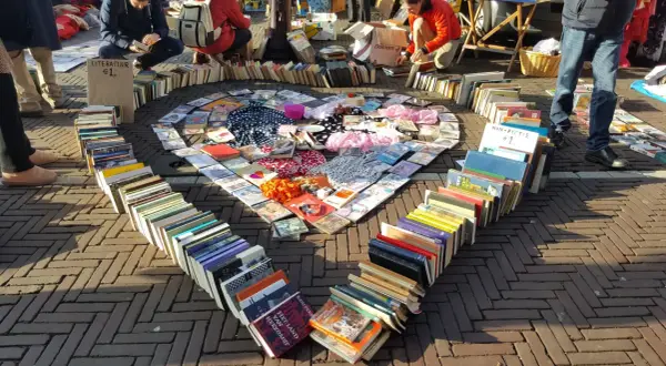 Herzförmige Anordnung von Büchern und CDs auf einem Flohmarkt. Tolle Flohmarkt Stand Ideen für Bücherliebhaber.