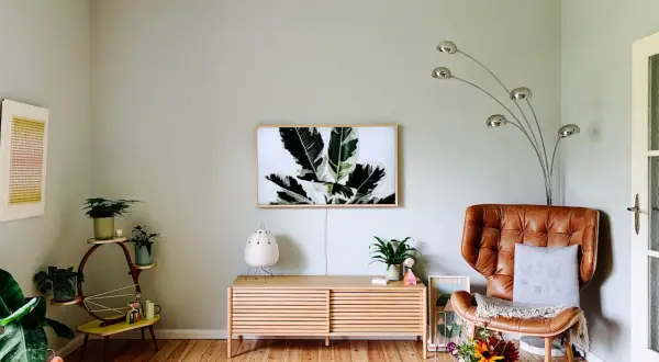 Sanfte Wandfarben Ideen für ein gemütliches Wohnzimmer mit Ledersessel, Pflanzen und Kunst.