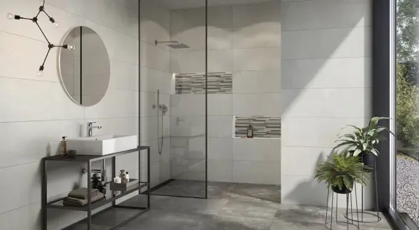 Modernes Bad mit Dusche, Waschbecken und Pflanzen. Die Wandfliesen mit Betonoptik verleihen dem Raum einen industriellen Touch.