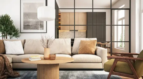 Gemütliches Wohnzimmer mit beigem Sofa, Holztisch und Blick in eine moderne Küche. Neue Wohntrends für ein stilvolles Zuhause.