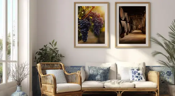 Stilvolle wandgestaltung hinter sofa mit Bildern von Trauben und Weinfässern. Ein Rattan-Sessel und ein Sofa laden zum Entspannen ein.