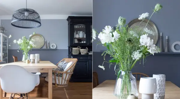 Schöne Esszimmer Wand Ideen: Ein Holztisch mit weißen Stühlen, ein schwarzer Schrank und ein Blumenstrauß.