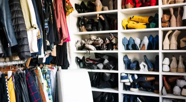 Kleiderschrank voller Schuhe und Kleidung. Zeit, Kleidung zu reduzieren und Ordnung zu schaffen.