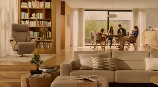 Familie am Esstisch, ein Sessel und ein Sofa in warmen, beigen Tönen. Die beige Wirkung schafft eine gemütliche Atmosphäre.