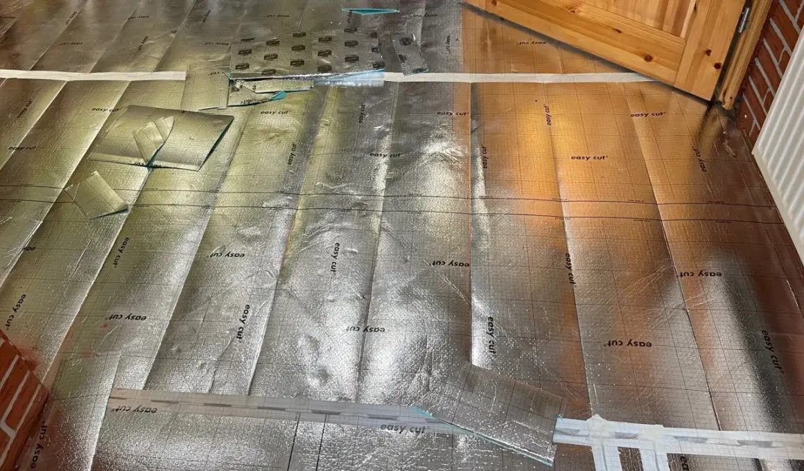 Bodenisolierung mit reflektierender Folie, bereit für die Verlegung im Badezimmer. Kork wird später darauf angebracht.