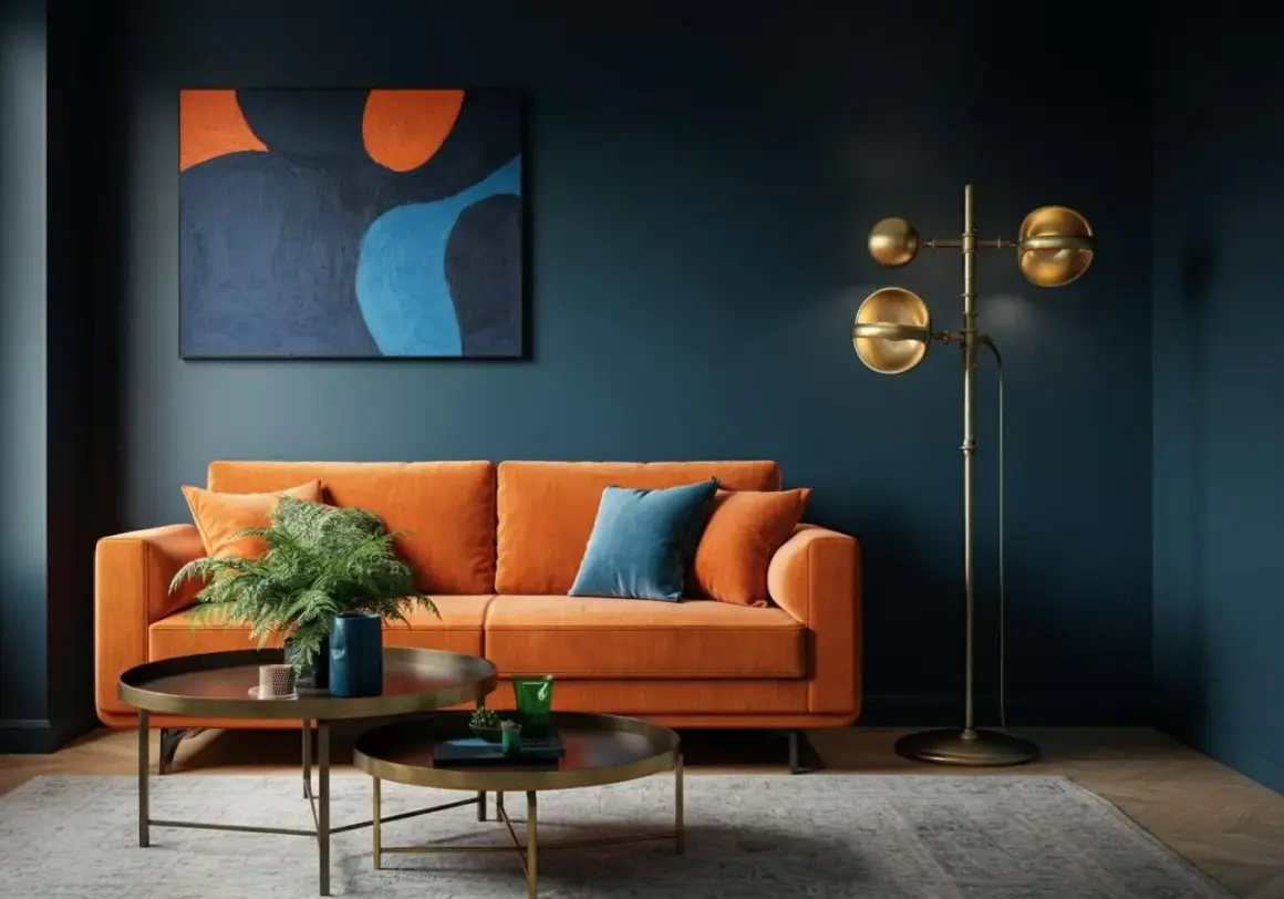Ein orangefarbenes Sofa vor einer dunkelblauen Wand. Die Frage, welche Farbe passt zu blau Wandfarbe, wird hier mit einem kräftigen Orange beantwortet.