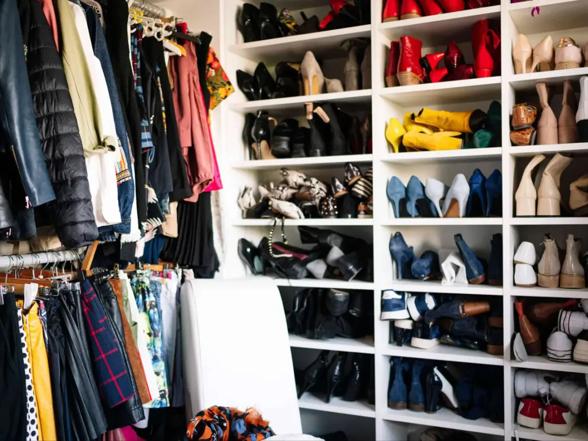 Kleiderschrank voller Schuhe und Kleidung. Zeit, Kleidung zu reduzieren und Ordnung zu schaffen.