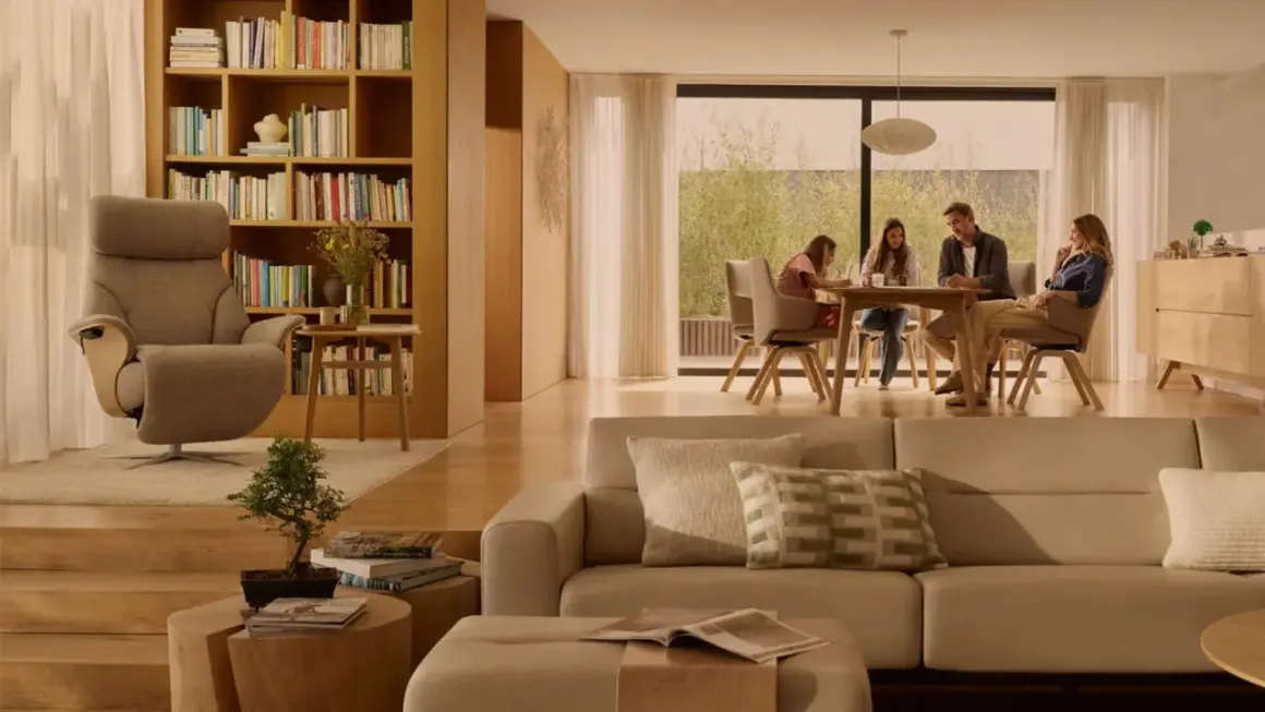Familie am Esstisch, ein Sessel und ein Sofa in warmen, beigen Tönen. Die beige Wirkung schafft eine gemütliche Atmosphäre.