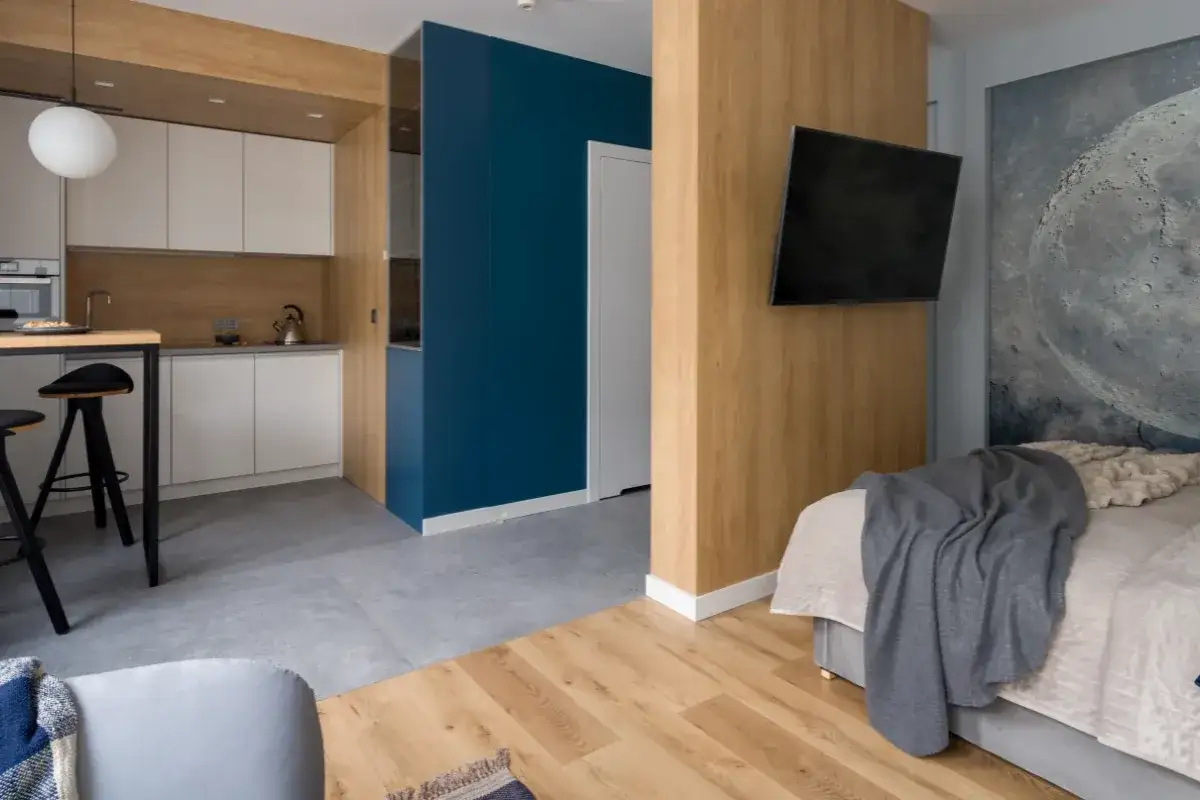 Minimalismus: Was braucht man wirklich? Ein modernes Studio mit K&uuml;che, Wohnbereich und Bett, alles in klaren Linien und beruhigenden Farben.