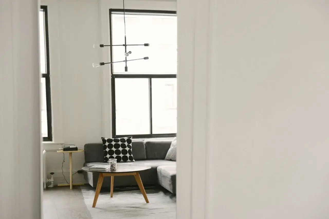 Gemütliches Wohnzimmer mit Sofa, Couchtisch und Fenster. Ein schönes Beispiel, wie man Dinge verschenken statt wegwerfen kann, indem man sie neu arrangiert.
