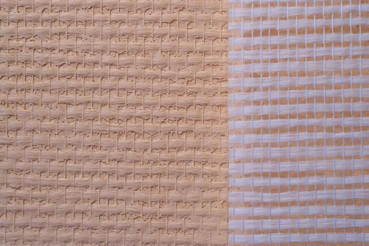 Nahaufnahme von atmungsaktiver Glasfasertapete mit feiner Textur und einem sichtbaren Gewebe.