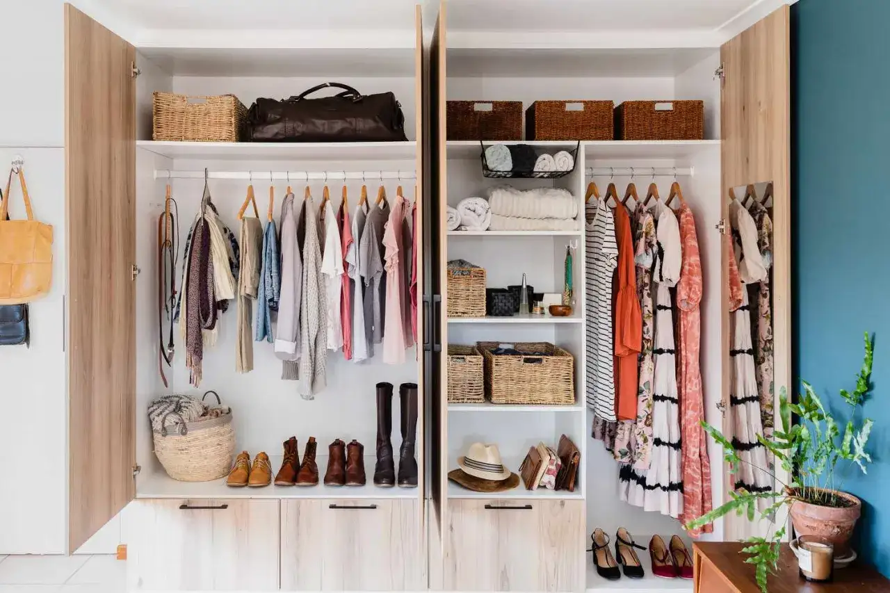 Ein Kleiderschrank voller Kleidung und Schuhe, K&ouml;rbe und Taschen. Sieht aus, als g&auml;be es zu viele Klamotten zu wenig Platz.