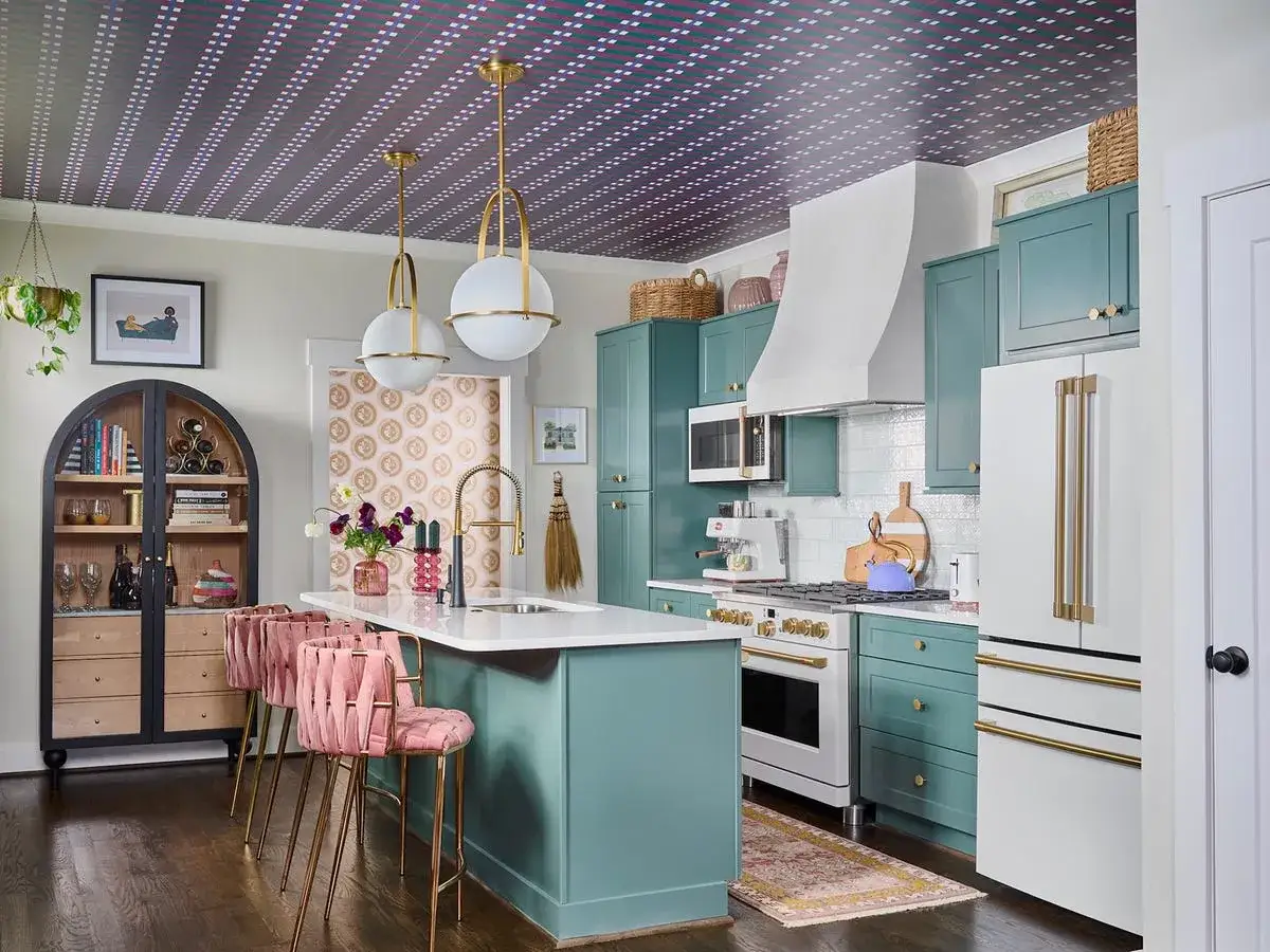 Eine K&uuml;che in Aqua-Blau mit rosa Barhockern und goldenen Akzenten. Welche Farbe passt zu Aqua-Blau? Hier sehen wir Rosa und Gold als harmonische Erg&auml;nzung.