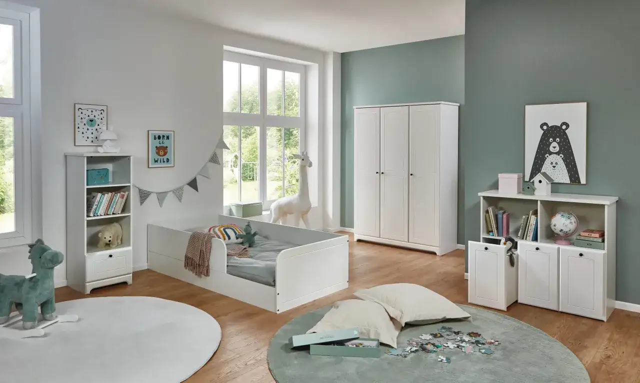 Ein heller, aufger&auml;umter Minimalismus Kinderzimmer mit wei&szlig;em Bett, Kleiderschrank und Regal. Spielzeug und Deko sind liebevoll platziert.