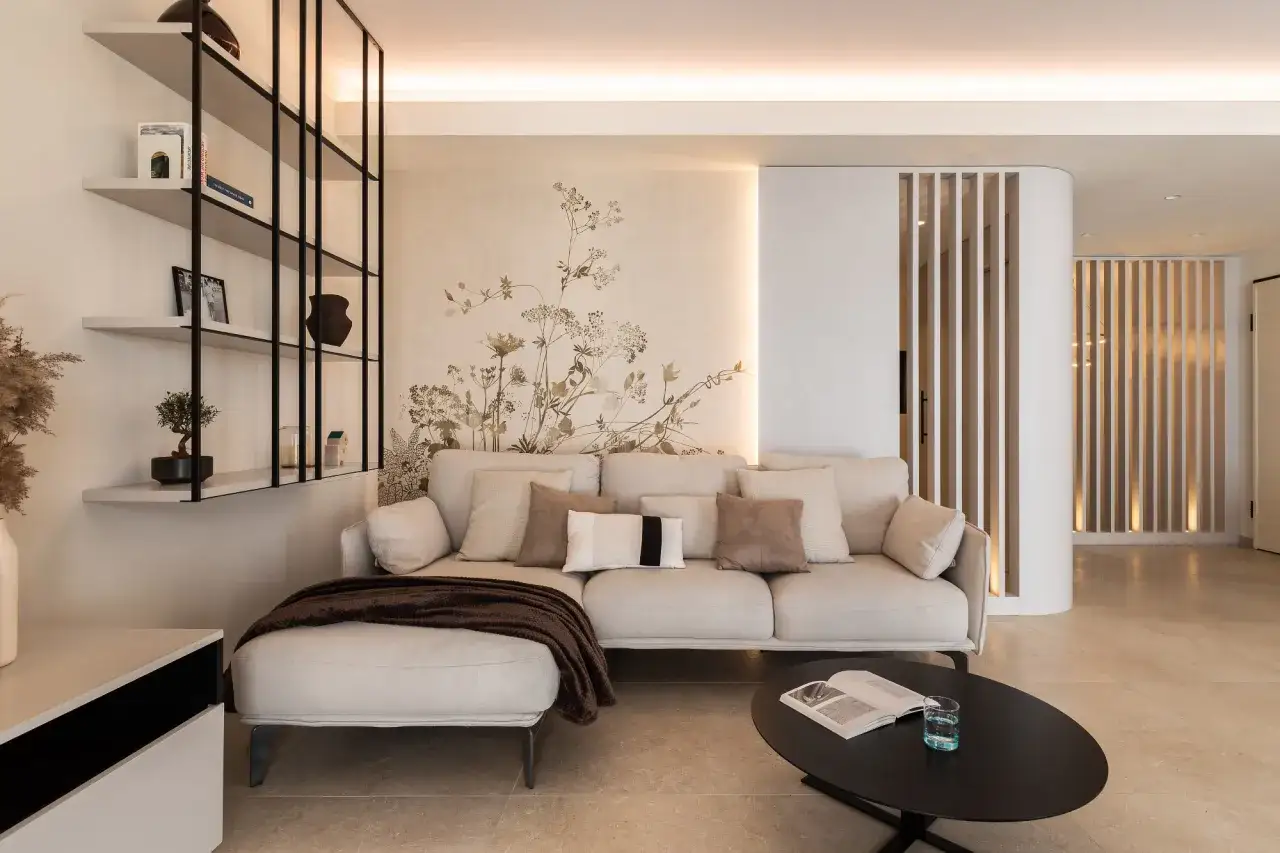 Gem&uuml;tliches Wohnzimmer mit beiger Couch, floraler Wandtapete und moderner Regalwand. Perfekte wohnung inspo f&uuml;r ein stilvolles Zuhause.