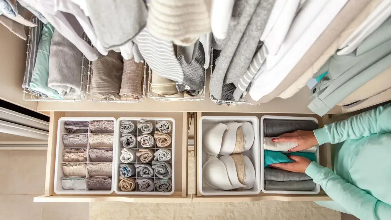 Kleiderschrank ausmisten: Wo anfangen? Ordentliche Schubladen mit Unterw&auml;sche, Socken und BHs. Oben h&auml;ngen Pullover und Kleider.