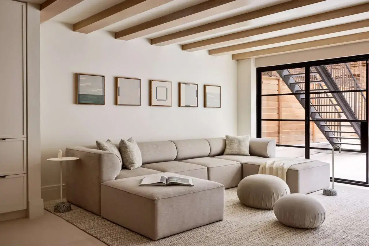 Ein Wohnzimmer in Sandfarben, das Ruhe ausstrahlt. Die Frage, welche Farbe passt zu Sand, wird hier elegant beantwortet.