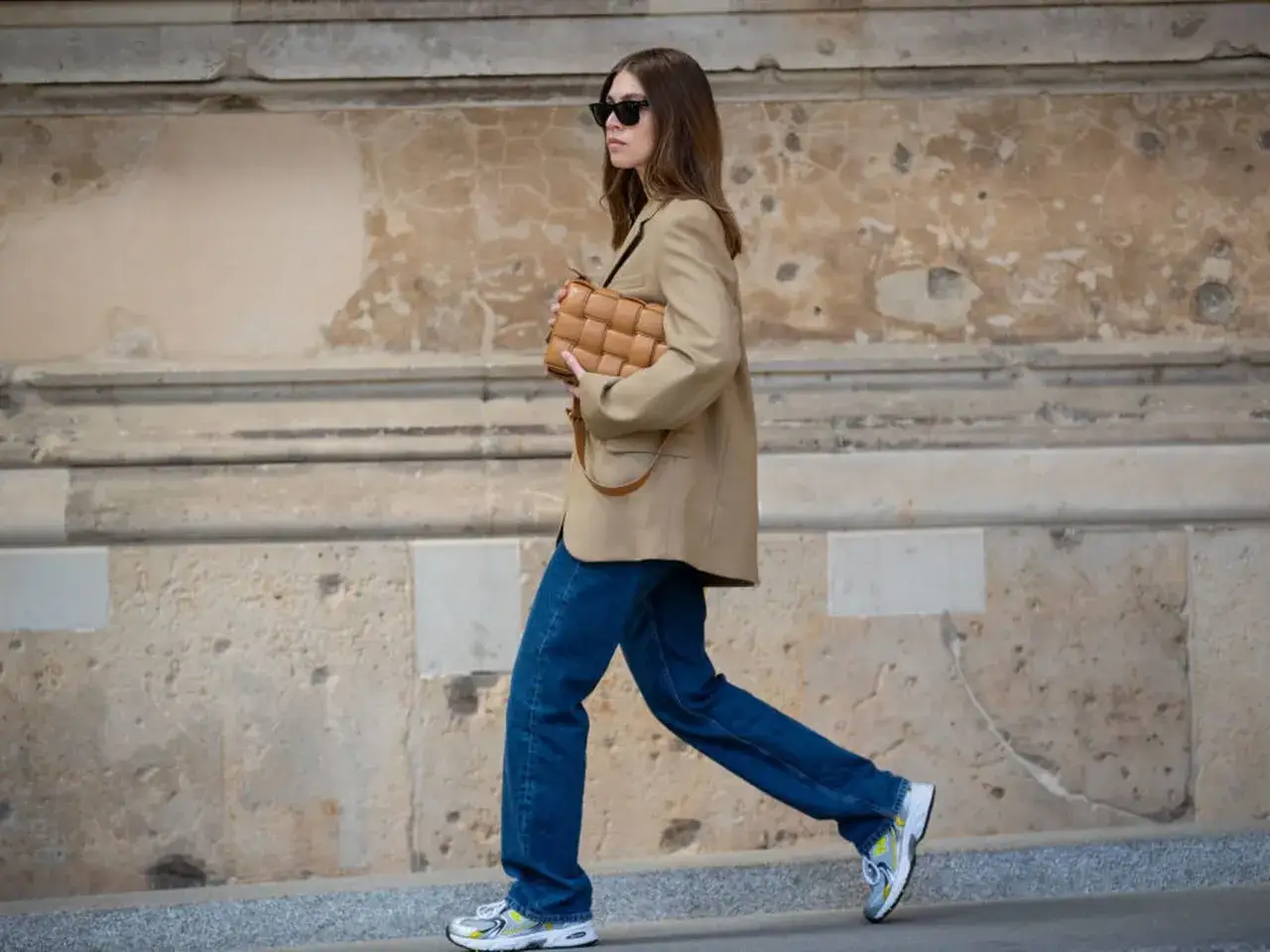 Frau mit braunem Blazer, Jeans und Tasche. Ein Beispiel für eine Capsule Wardrobe: Wenige, vielseitige Teile für viele Looks.