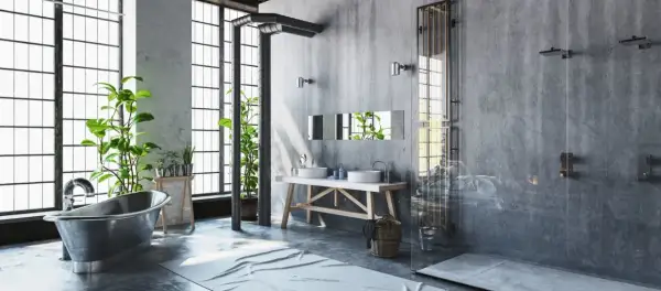 Badezimmer im bad industrielook mit Betonwänden, freiliegenden Rohren, einer Metallbadewanne und Pflanzen.
