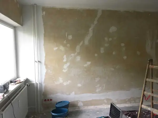 Vorbereitung für das selbst tapezieren: Wand ist vorbereitet, Werkzeug und Eimer stehen bereit.